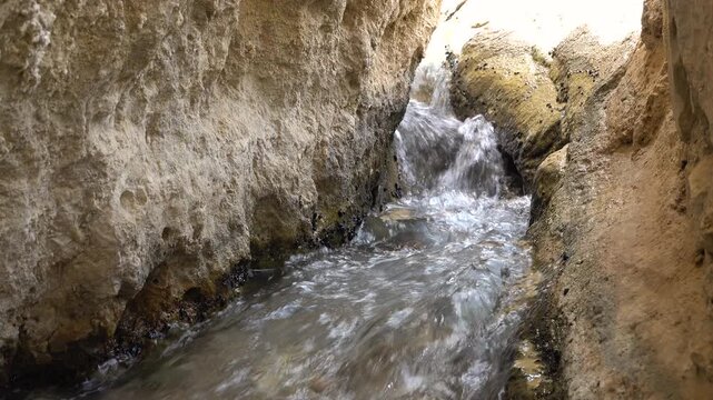 Tunisia natural scenery and landmarks, water flows through mini gorge in desert oasis of Chebika