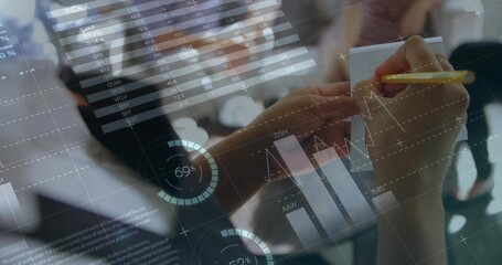 Holding yellow pencil, analyst writing notes on notepad in office, with overlaid financial charts