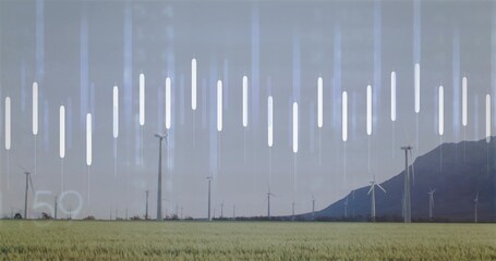 Spinning white wind turbines rotating across green field at mountain slope, with data bars faint 5°