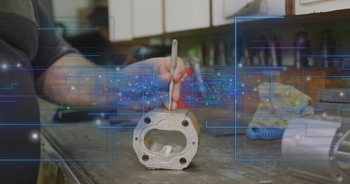 Holding pick tool technician wearing dark shirt scraping cast cylinder head at garage workbench - Powered by Adobe