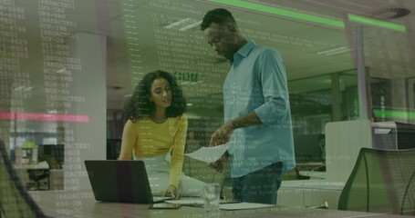 Collaborating woman and male colleague reviewing documents in office, with laptop printed sheets