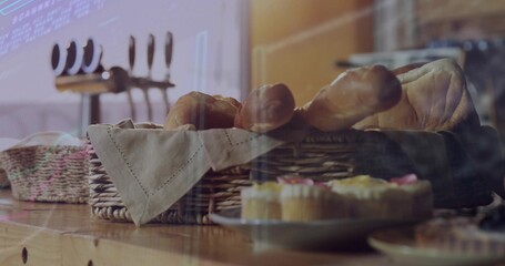 Showcasing wicker basket holding bread loaves and baguettes in bakery, with frosted cupcakes