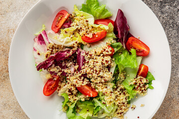 Quinoa salad tomato, green leaf salad vegetables dish natural product tasty snack fresh gourmet food background on the table rustic top view copy space keto and paleo diet vegan and vegan food
