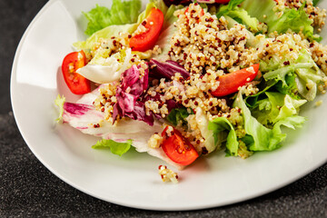 Quinoa salad tomato, green leaf salad vegetables dish natural product tasty snack fresh gourmet food background on the table rustic top view copy space keto and paleo diet vegan and vegan food