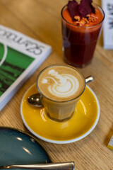 coffee on wooden table next to books