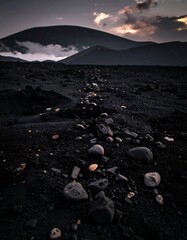 Dark landscape with a rocky path leading towards distant mountains