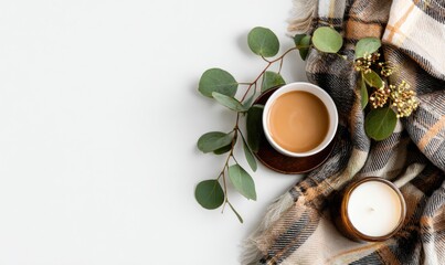 Cozy morning with tea, eucalyptus, and candle on soft blanket