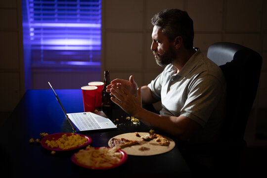 Mature Overworked businessman works late at night on his laptop. Busy employee overworked in office work during a late-night. Freelancer overworked in late night. Deadline and overwork concept.