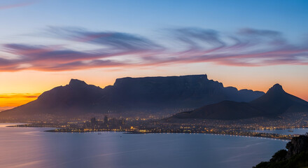 Breathtaking table mountain silhouette at sunset with vibrant sky over tranquil ocean waters