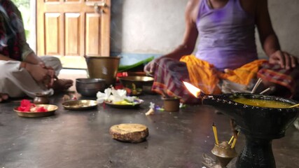 Close-up of Shivling pooja with milk, flowers, and bael leaves being offered. Indian people performing sacred havan on the occasion of Mahashivratri, offering ghee. Focused on foreground