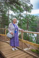 An elderly woman on a tourist trip on island of Valaam. Russia. Observation deck