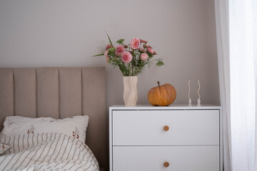 Transform your bedroom into a stylish space with a bouquet, decorative pumpkin, and chic, comfortable furniture.