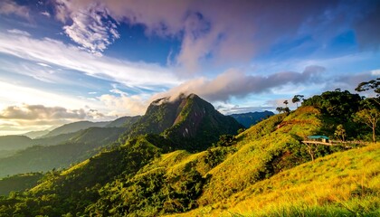 Obraz premium Verdant hills and a cloud-draped peak under a vibrant sky, capturing a serene, natural landscape at golden hour