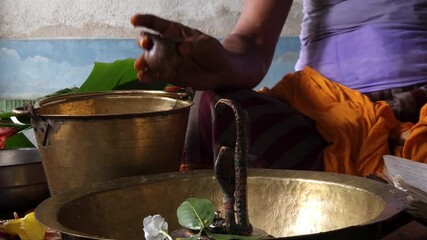 Close-up of Shivling pooja with milk, flowers, and bael leaves being offered. Indian people performing sacred havan on the occasion of Mahashivratri, offering ghee to the holy fire during  Vedic puja.