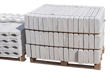 The pallet with a stack of concrete curbstone on white