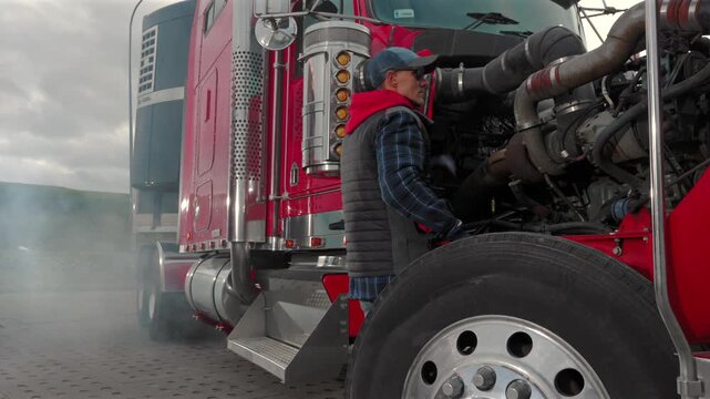Truck Driver Performs Maintenance on a Big Rig at a Loading Dock