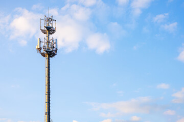 Cell tower of 4G and 5G against a blue sky. Antennas for mobile internet communications.