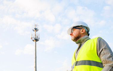 Inspecting 4G and 5G network equipment. Inspection and maintenance of cellular communication poles. Male engineer maintains a telecommunications tower. 