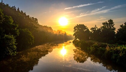 Golden sunrise reflects on tranquil river, illuminating forest banks