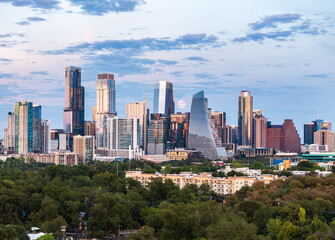 Aerial drone view of the Austin Texas skyline as the full harvest moon is seen rising by the office buildings. Zilker Park in the foreground.