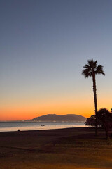 Obraz premium Sunrise over the sea in Rincón de la Victoria, Malaga, Spain, with golden light reflecting on calm waves along the coast.