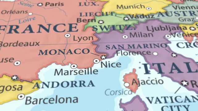 4K macro video of Monaco on a world map with shallow depth of field. Focus on word Monaco and surrounding areas including France, Italy, and the Mediterranean coast. Travel geography footage