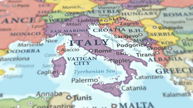 4K macro video of Italy on a world map with shallow depth of field. Focus on word Italy and surrounding areas including France, Switzerland, Austria, and the Mediterranean Sea. Travel footage