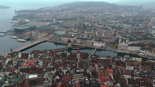 Foggy Lucerne aerial, Switzerland. Historic cityscape with old town, Reuss river, Chapel Bridge and Water Tower. Scenic Swiss landmark panorama with cloudy dramatic sky