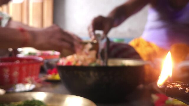 Close-up of Shivling pooja with milk, flowers, and bael leaves being offered. Indian people performing sacred havan on the occasion of Mahashivratri, offering ghee. Focused on foreground