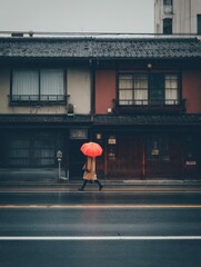 Person Walking with Red Umbrella in Rainy Urban Setting Next to Traditional Buildings