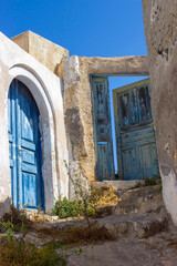 Fototapeta premium old door of white house in Magalochori town on Santorini island, Greece