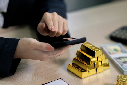 businesswoman investing in gold with digital device