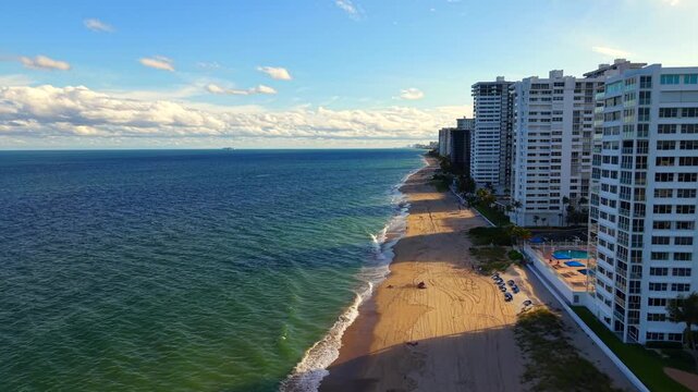 Long building shadows in the sea. Aerial drone video highrise condominiums in Fort Lauderdale Beach Florida 2025