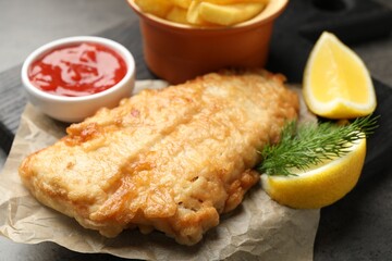 British Traditional Fish and chips served with sauce on grey table, closeup