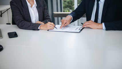 Lawyer preparing to sign a contract reading documents at meeting