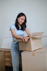 Female Asian organizing personal items for house relocation to new place
