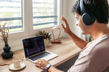 Young hispanic man teleworking from home on video call