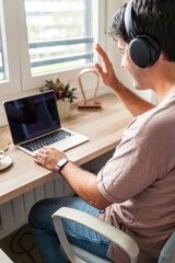 vertical Young Hispanic man on a video call teleworking from home