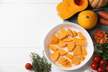Fresh pumpkins and ingredients on white wooden table, flat lay. Space for text