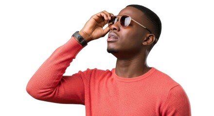Man adjusting sunglasses looking upward with intense gaze wearing coral sweater isolated on white background