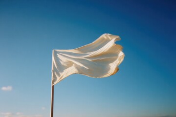 Silk flag gently waves against clear blue sky, creating serene and peaceful atmosphere