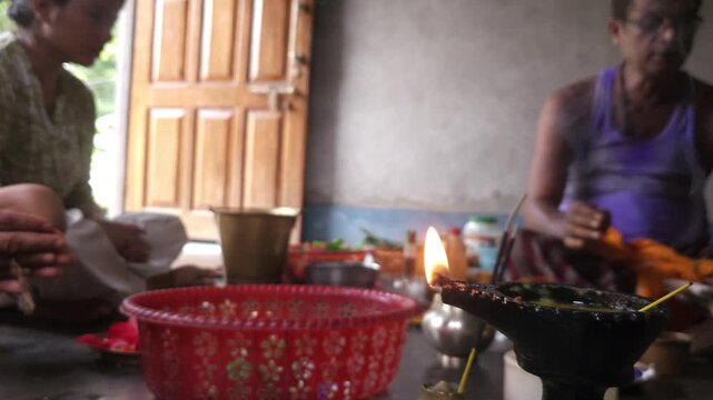 Close-up of Shivling pooja with milk, flowers, and bael leaves being offered. Indian people performing sacred havan on the occasion of Mahashivratri, offering ghee. Focused on foreground