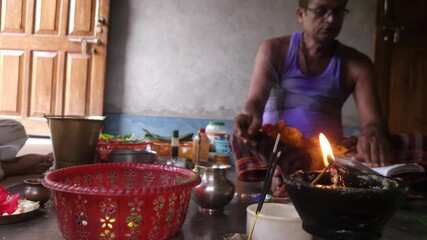 Close-up of Shivling pooja with milk, flowers, and bael leaves being offered. Indian people performing sacred havan on the occasion of Mahashivratri, offering ghee. Focused on foreground