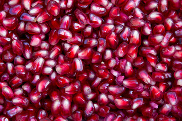 Full frame photo of red pomegranate seeds or arils, background and texture.