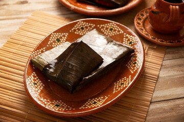 Oaxacan Tamales. A pre-Hispanic dish typical of Mexico and some Latin American countries. Corn dough wrapped in banana leaves is filled with meat or a stew. Tamales are steamed.