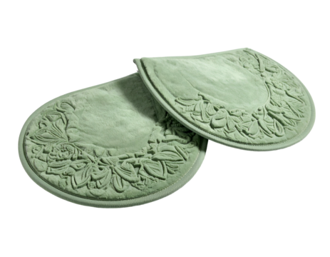 Two pale green, ornate, oval-shaped decorative objects, possibly wall decor, against black