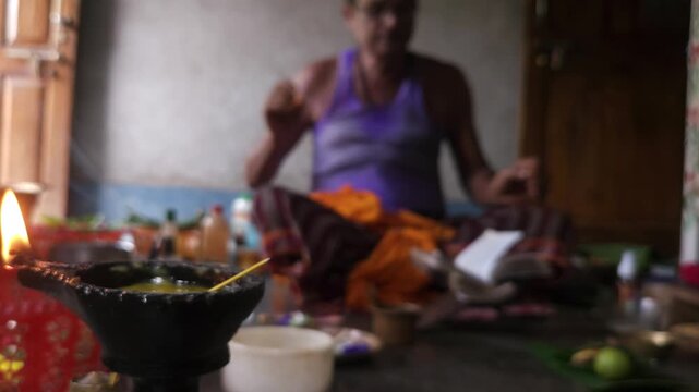 Close-up of Shivling pooja with milk, flowers, and bael leaves being offered. Indian people performing sacred havan on the occasion of Mahashivratri, offering ghee. Focused on foreground