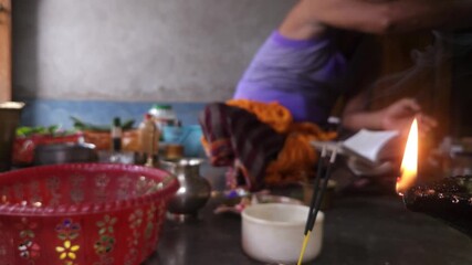 Close-up of Shivling pooja with milk, flowers, and bael leaves being offered. Indian people performing sacred havan on the occasion of Mahashivratri, offering ghee. Focused on foreground