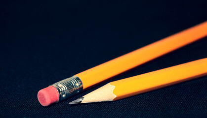 Two yellow Pencils on dark black blurred background. stationery. Office tool. Business concept. Back to school. Draw.