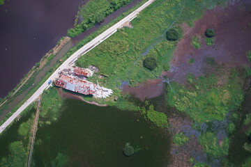 Aerial view of flooded rice fields, irrigation canals, and expanding urban settlements in Sungai Penuh, Jambi, Indonesia. Showing urban sprawl, farmland conversion, and environmental landscape.
